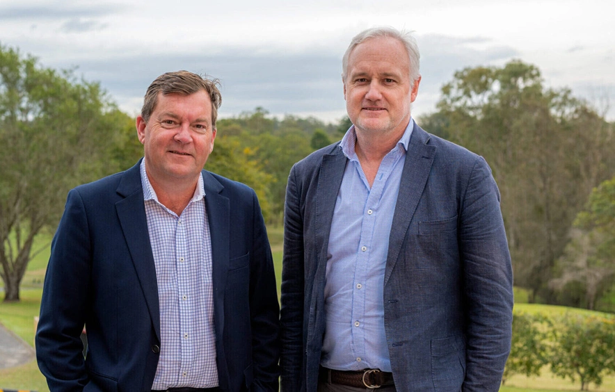 Two men standing outdoors at Aura Holdings